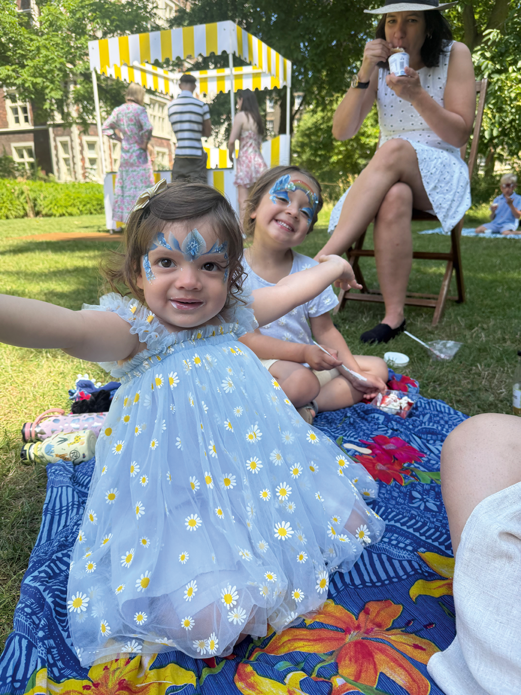 Young girls with their faces painted with fairy patterns 