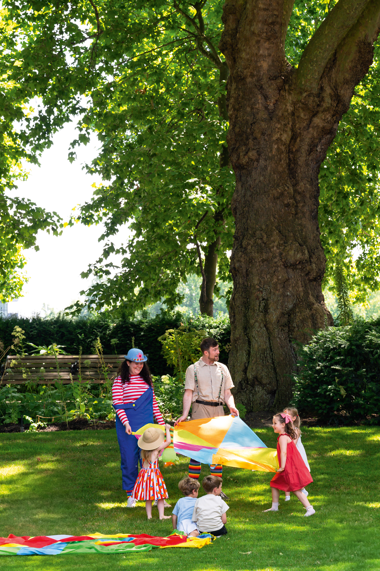 People playing with a rainbow parachute toy