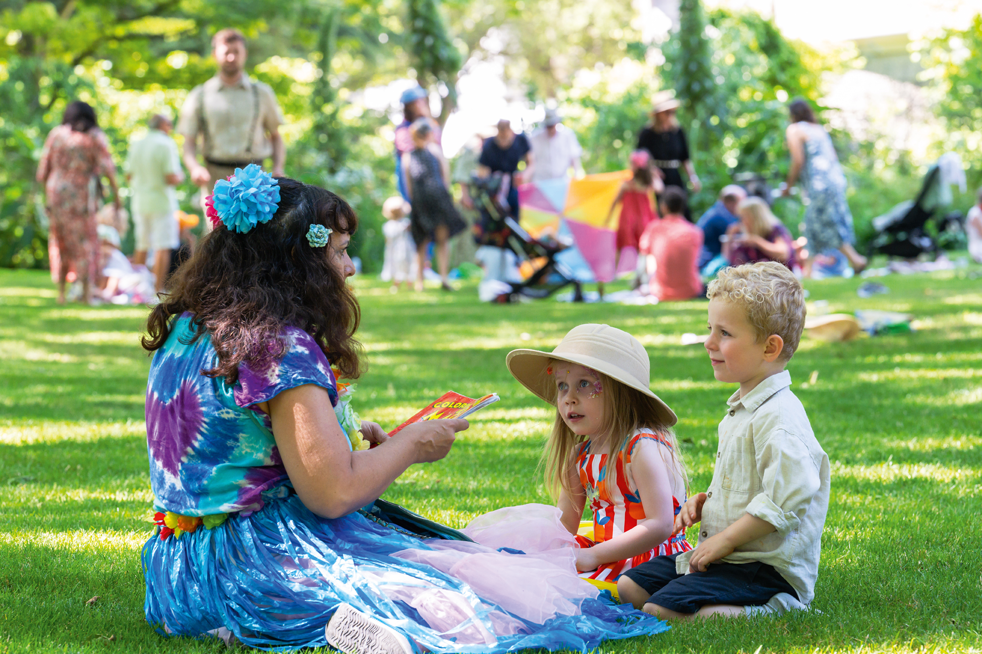 Children gathered and listening to a story on the lawn