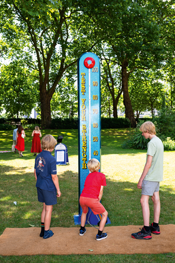 Young boys playing a hammer bell fair game