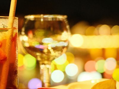 A wine glass catching the candlelight at dinner, promotional image for Bar Guest Night