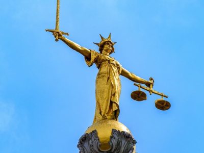 The statue of Lady Justice on the dome of the Old Bailey against a blue sky