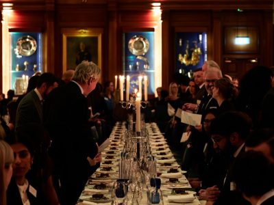 Students and members dining by candlelight in Hall at the Dinner to the Universities